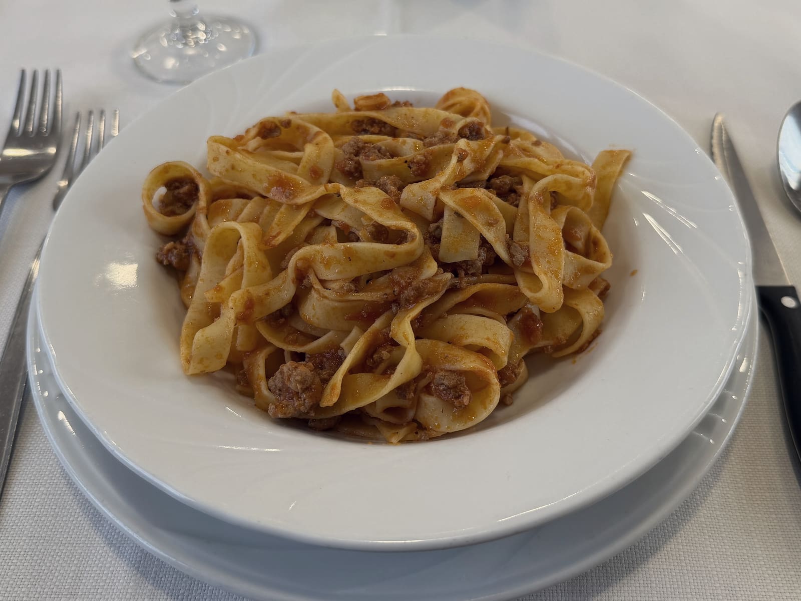 Tagliatelle al ragù sul tavolo apparecchiato della sala